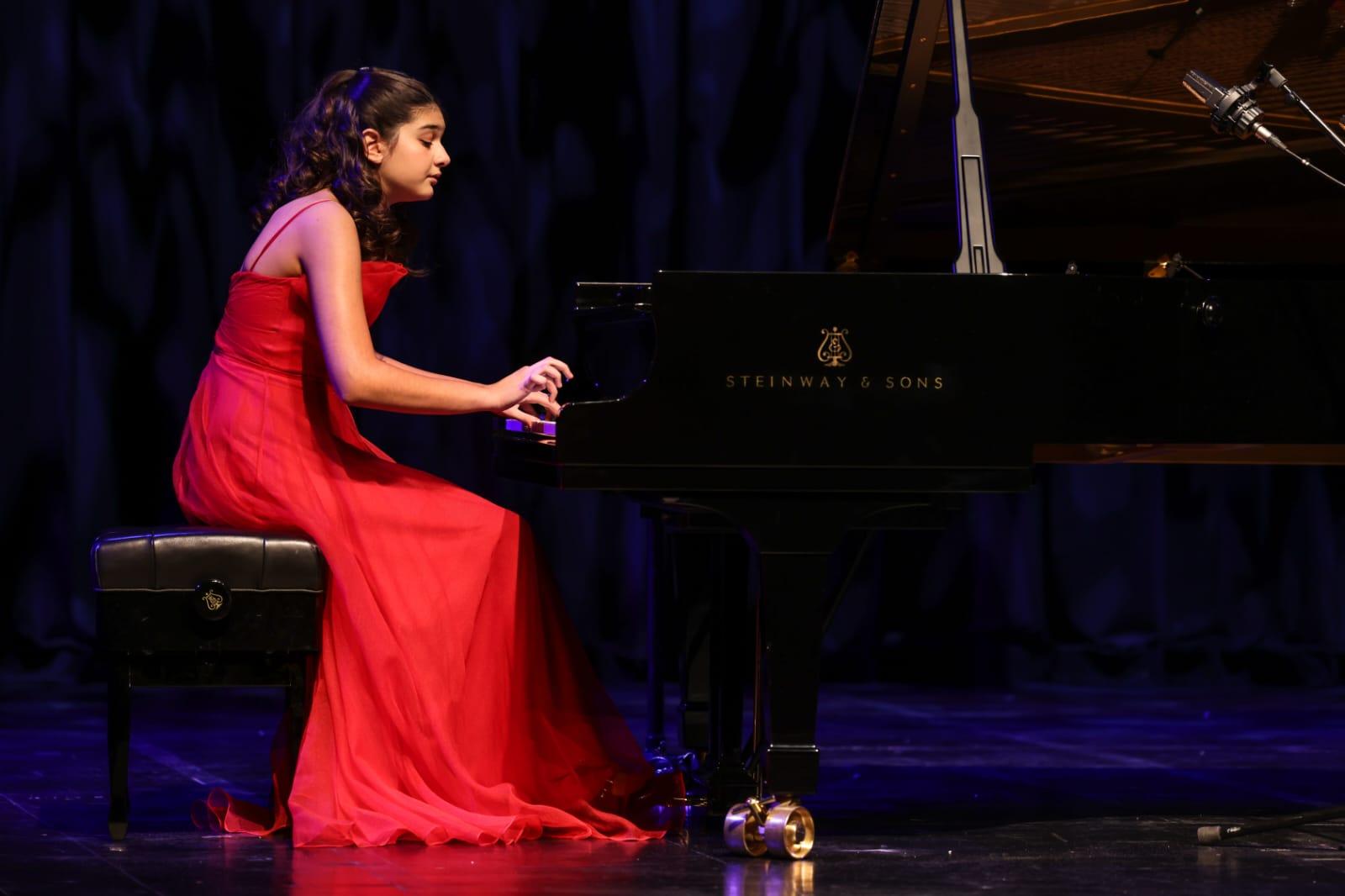 Elif Naz Ertuğrul performing at a grand piano in a concert hall
